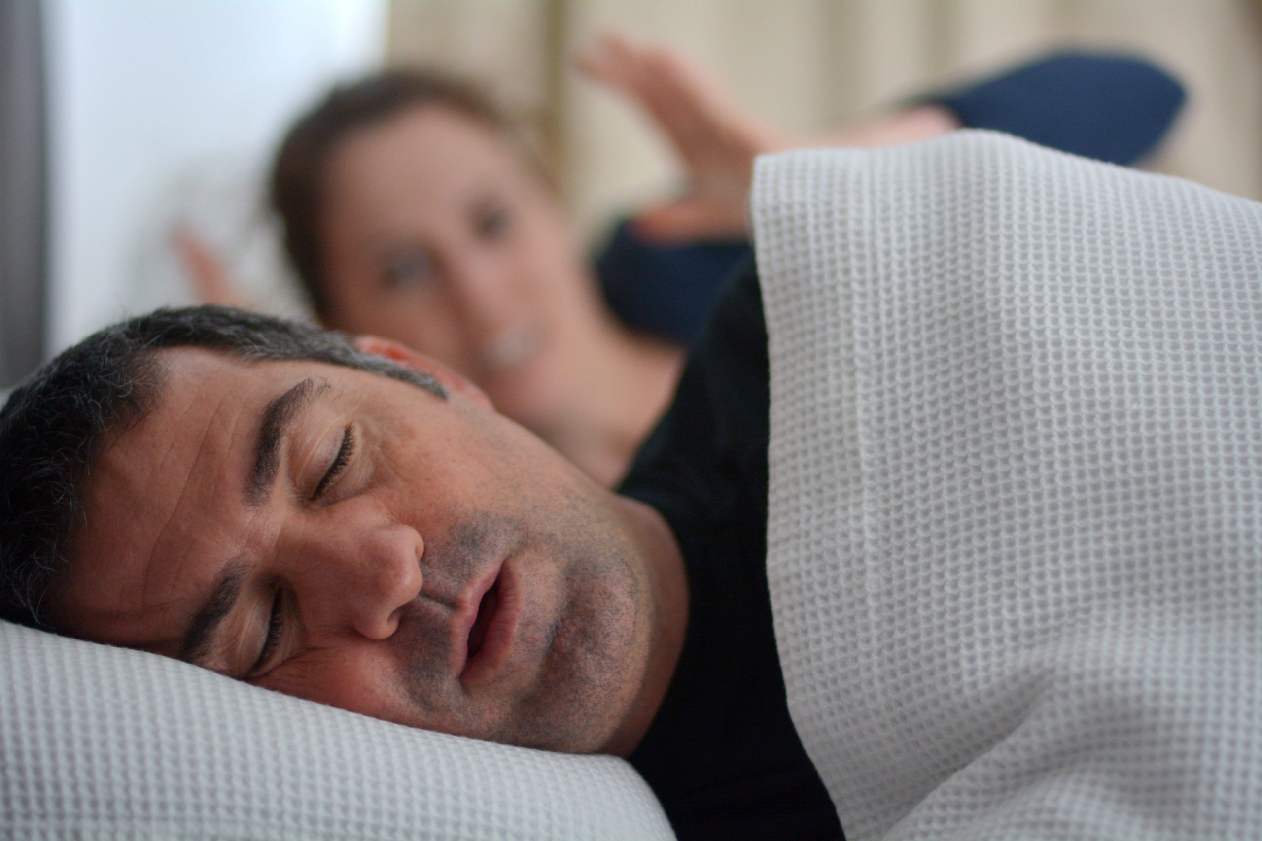 Woman suffers from her male partner snoring in bed