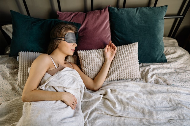 woman in bed with sleeping masks - featured image