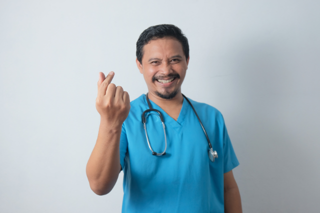 male nurse doing the finger heart sign