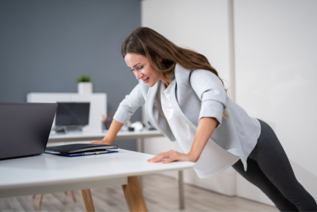 woman doing push ups in the office