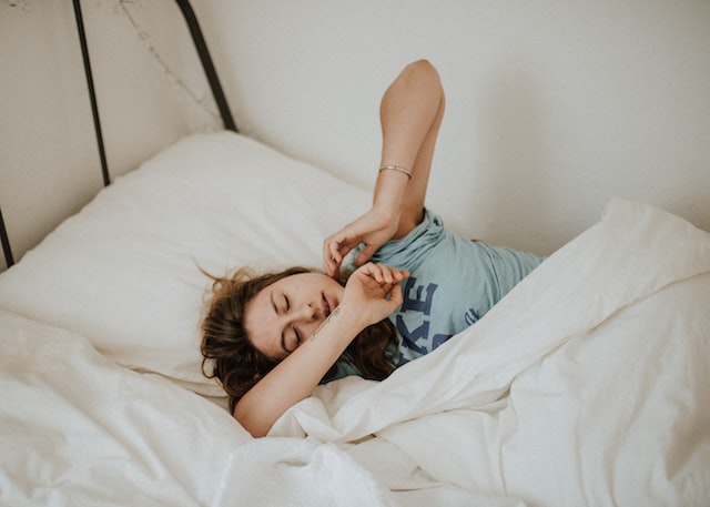 woman covered in white set of beddings