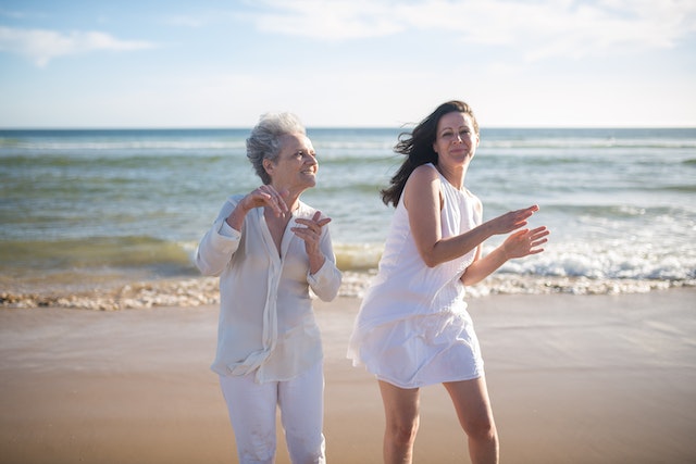mid-age and elderly lady dancing on the beach