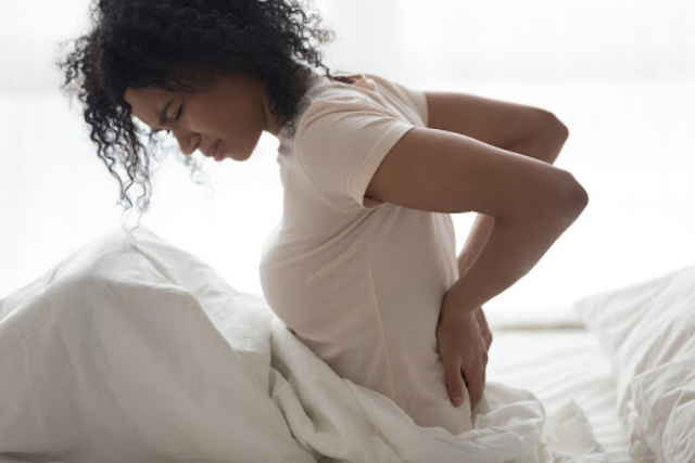 a woman having back pains from sleeping on a wrong mattress