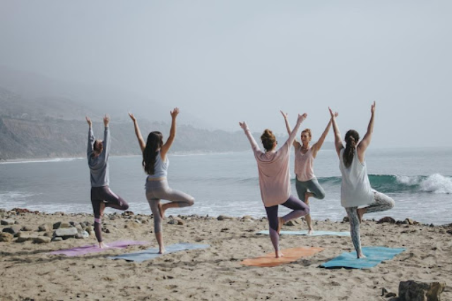 a group of community friends exercising by the seashore