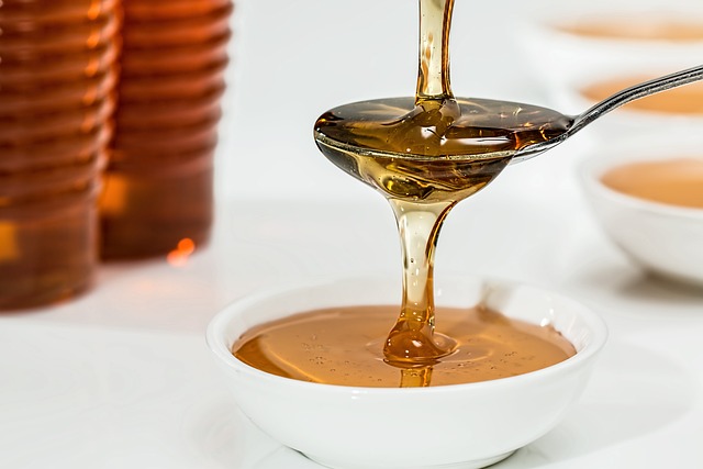 dripping honey on a metal spoon