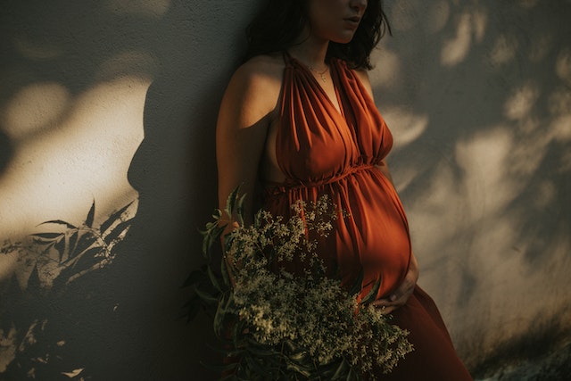 pregnant woman with her back on the wall
