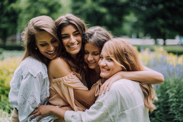 4 women happily hugging each other